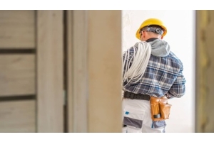 Electricista usando materiales aislantes eléctricos en un sistema eléctrico